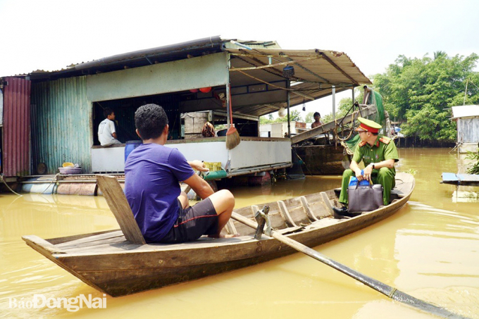 Lực lượng công an phường chèo ghe đi từng bè để trả thẻ CCCD cho người dân. Ảnh: Công an cung cấp