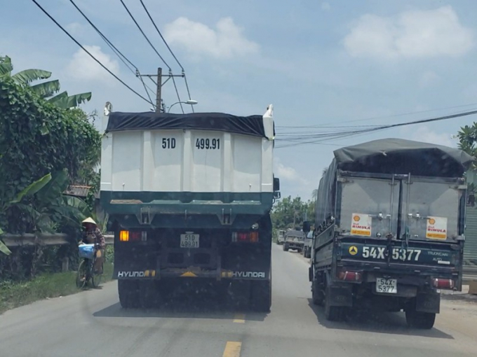 Xe ben vượt xe tải, ép xe đạp ở làn đường ngược lại dạt vô tận lề. Ảnh: T.SANG