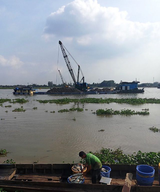Vài ngày trước, người dân sống ven sông Hậu (xã Long Giang, huyện Chợ Mới) tố cáo doanh nghiệp khai thác cát sông làm vỡ ô bao vuông nuôi cá, khiến cá chết hàng loạt (ảnh: Nguyễn Hành).