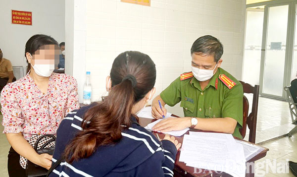 Điều tra viên Công an TP.Biên Hòa làm việc với những người dân đến trình báo bị đối tượng sử dụng mạng xã hội để lừa đảo. Ảnh: TRẦN DANH