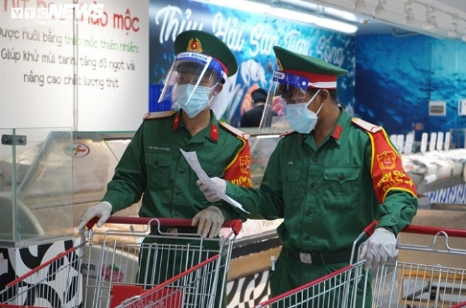 Tại TP.HCM, cán bộ thuộc nhiều lực lượng đang hằng ngày đi chợ hộ dân.