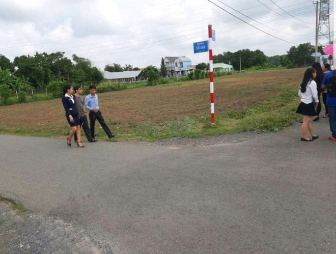 Nhân viên Công ty Việt Á dụ khách hàng đi mua đất, ảnh Đình Sơn