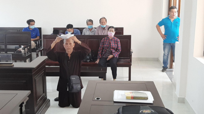 Hình ảnh cụ ông đội đơn quỳ gối tại tòa
