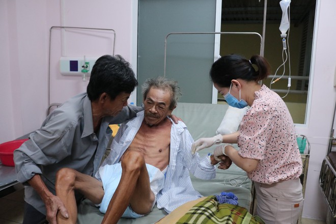 Nhiều người nhà bệnh nhân khác trong phòng bệnh cũng giúp đỡ hai chị chăm sóc cụ ông. ẢNH: NVCC