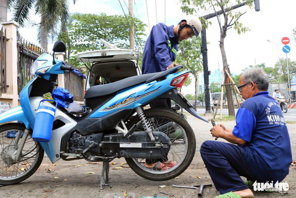 Ông Ngân vá xe tốc hành cho một công nhân để anh này kịp giờ làm - Ảnh: NHẬT THỊNH