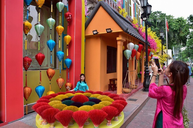 Các tiểu cảnh check - in chụp hình được trang trí thành 3 khu vực với đặc trưng Tết 3 miền. Nổi bật là mô hình một ngôi nhà cổ đặc trưng của phố cổ Hội An được dựng lên, mái trang trí hoa giấy, treo những đèn lồng, chùm que hương nhiều màu sắc.