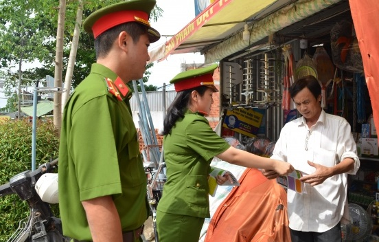 Công an cơ sở phát tờ gấp tuyên truyền phòng, chống tội phạm đến người dân (Ảnh: Mộng Tuyền)