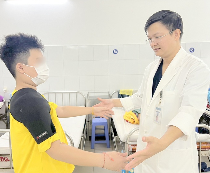Bác sĩ kiểm tra tình trạng sức khỏe của em Nguyễn N.H trước khi xuất viện 