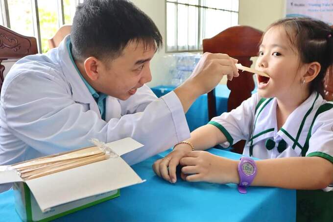 Bác sĩ thăm khám, kiểm tra răng miệng cho học sinh tiểu học