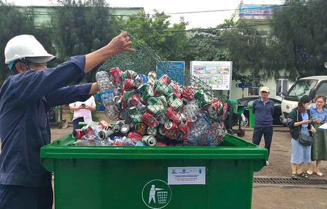Đội thu gom rác thải đang gom rác từ tàu cá mang về (ảnh: Ái Trinh)