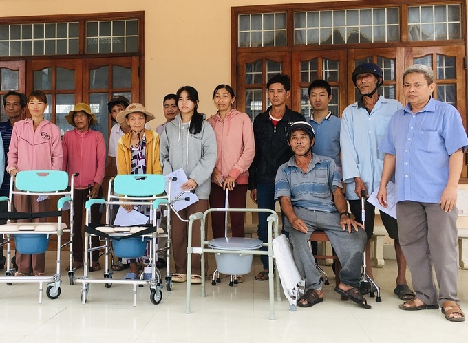 Người khuyết tật và người nhà nhận dụng cụ trợ giúp từ dự án hòa nhập 2b do Tổ chức CRS cấp phát (ảnh:Thu Hiền)