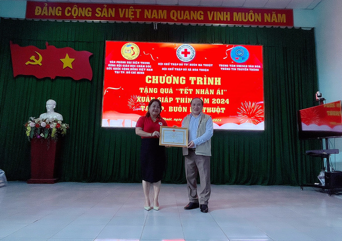 Bà Phạm Khánh Quyên - Chủ Tịch Hội Chữ Thập Đỏ TP. Buôn Ma Thuột trao tặng ghi nhận người tốt việc thiện chung sức xây dựng cộng đồng nhân ái cho Ông Phạm Đình Vương, Trưởng Văn phòng đại diện Trung ương Hội Giáo dục chăm sóc sức khoẻ cộng đồng Việt Nam tại TP. HCM, Giám đốc Trung tâm UNESCO Văn hoá Thông tin truyền thông