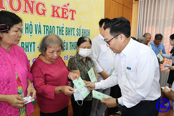 Ông Võ Khánh Bình - Giám đốc bảo hiểm xã hội tỉnh Tiền Giang trao tặng thẻ bảo hiểm y tế cho người dân  