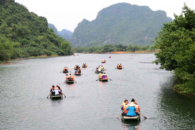 Đông đảo du khách đi thuyền tận hưởng không khí mát mẻ, làng nước trong xanh tại Khu du lịch Tràng An, Ninh Bình