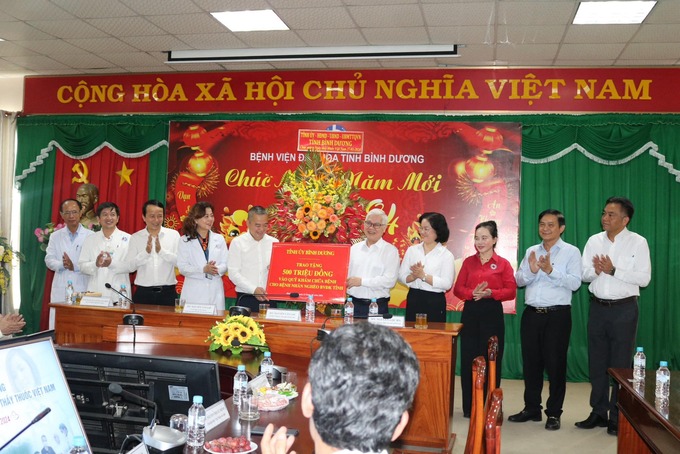 Đại diện đoàn công tác , ông Nguyễn Văn Lợi trao 500 triệu đồng từ nguồn xã hội hóa vào quỹ khám chữa bệnh cho bệnh nhân nghèo điều trị tại Bệnh viện