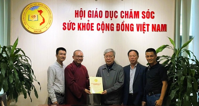 Ông Nguyễn Hồng Quân, Chủ tịch Hội Giáo dục chăm sóc sức khỏe cộng đồng Việt Nam trao quyết định thành lập Chi hội Bông Sen Trắng cho Ban Sáng lập Chi hội