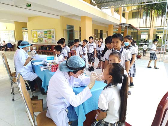 Nhân viên y tế khám răng cho học sinh tại trường Tiểu học Đông Bình (Ảnh: Lê Huy)