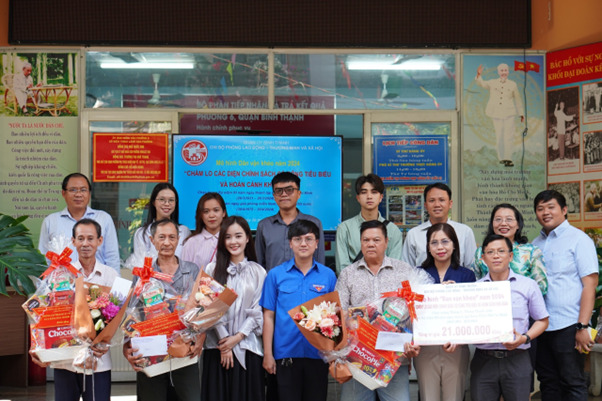 Bà Nguyễn Thu Hiền – Trưởng Phòng Lao động - Thương binh và Xã hội quận Bình Thạnh (vị trí thứ hai, hàng dưới, từ bìa phải) trao quà cho người dân