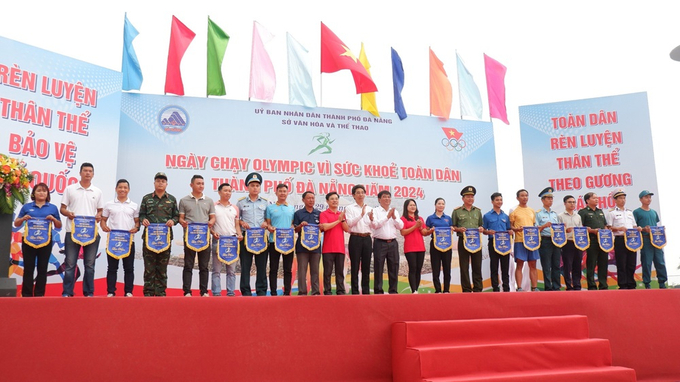 Phó Chủ tịch UBND thành phố Trần Chí Cường trao cờ lưu niệm cho 19 đơn vị