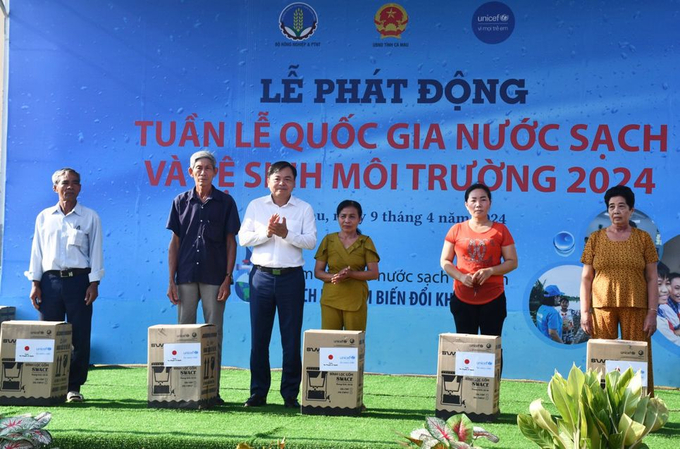 Thứ trưởng Bộ Nông nghiệp và Phát triển nông thôn Nguyễn Hoàng Hiệp (thứ 3, trái sang) trao máy lọc nước cho người dân