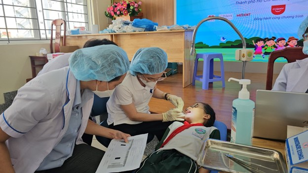 Học sinh với sự đồng thuận của phụ huynh được khám tầm soát sức khỏe răng miệng tại trường tiểu học Bàu Sen