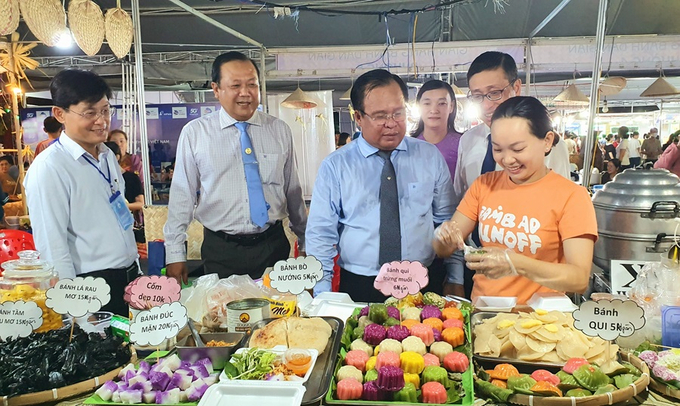 Phó Chủ tịch UBND tỉnh Cà Mau Nguyễn Minh Luân (người thứ 3 từ trái sang) tham quan gian hàng bán bánh dân gian