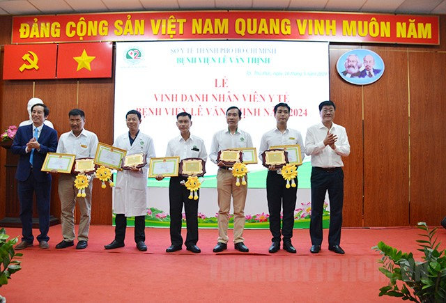 Ông Bùi Văn Phúc  và BS.CKII Trần Văn Khanh trao giấy khen và bảng vinh danh các nhân viên y tế có thành tích tiêu biểu