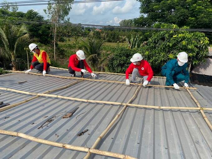 Thành viên đội phòng ngừa ứng phó thảm họa thực hành thao tác chằng chống nhà cho người dân 