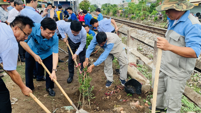 Các đại biểu tham gia trồng hoa dọc đường tàu (Ảnh: MH)