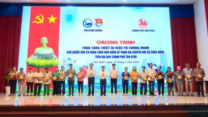 Ông Nguyễn Lộc Hà - Phó Chủ tịch UBND tỉnh Bình Dương cùng ông Bùi Minh Trí - Bí thư Thành uỷ Tân Uyên trao tặng điện thoại thông minh cho người có hoàn cảnh khó khăn