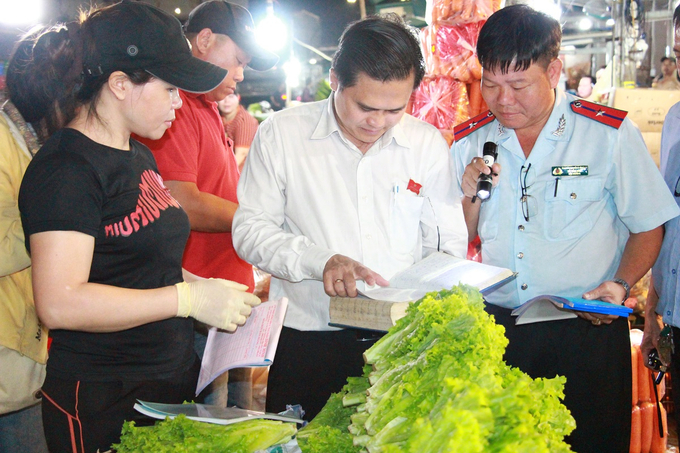 Ông Cao Thanh Bình (ở giữa) kiểm tra sổ ghi chép xuất xứ hàng hoá