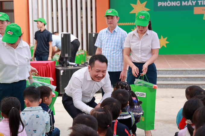 Đại diện Vụ Giáo dục tiểu học, Bộ Giáo dục và Đào tạo, trao quà cho các em học sinh trong buổi lễ trao tặng phòng máy tính tại điểm trường Khao Mang