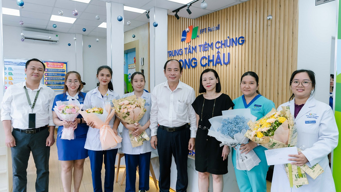 PGS.TS.BS Tăng Chí Thượng tặng hoa chúc mừng ê-kíp y, bác sĩ của Hệ thống nhà thuốc và tiêm chủng FPT Long Châu đã phối hợp cấp cứu sốc phản vệ thành công cho người bệnh