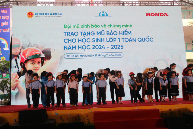 Ban Tổ chức trao mũ bảo hiểm cho các em học sinh Trường Tiểu học Giồng Ông Tố