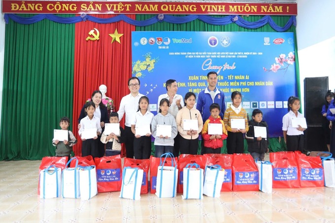 Bác sĩ Nguyễn Trung Thành và các đại biểu trao quà cho các em học sinh có hoàn cảnh khó khăn (Ảnh: Đình Thi)