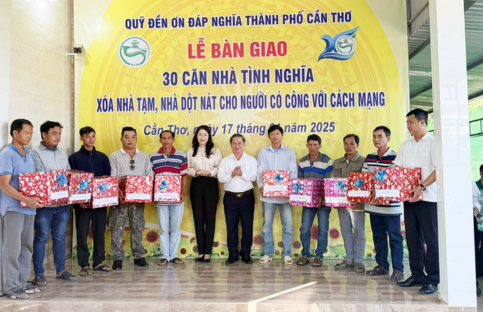 Chủ tịch UBND TP Cần Thơ Trần Việt Trường tặng quà cho các hộ gia đình được nhận nhà tình nghĩa (Ảnh: Lê Hoàng Hải)