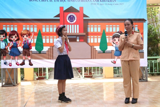 Chiến sĩ CSGT hướng dẫn học sinh cách đội mũ bảo hiểm đúng chuẩn khi tham gia giao thông