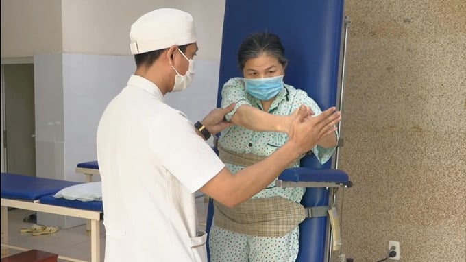 Nhân viên y tế hướng dẫn bà H. tập phục hồi chức năng (Ảnh: BVCC)