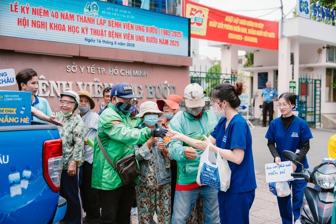 Những tài xế công nghệ, người bán hàng rong, người dân xếp hàng chờ thăm khám,... ghé nhận nước uống miễn phí giữa trưa nắng