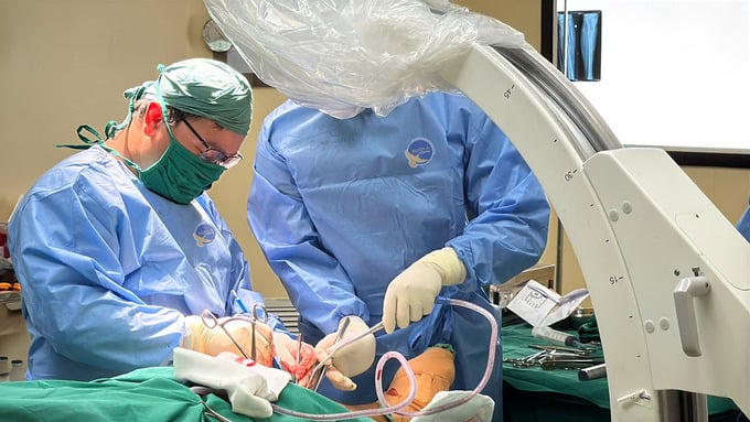 Ekip phẫu thuật dưới hướng dẫn của hệ thống màn hình tăng sáng (C-arm) (Ảnh: BVCC)