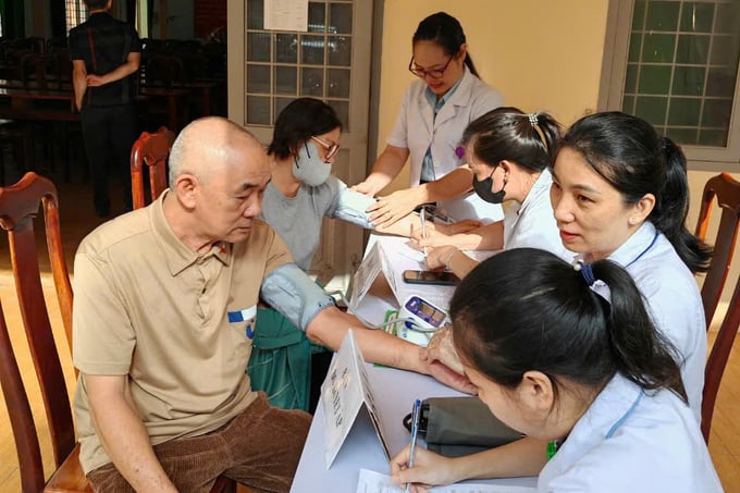 Cán bộ y tế phường Tân Tiến đo huyết áp và thăm khám cho người cao tuổi (ảnh: Thu Phượng)